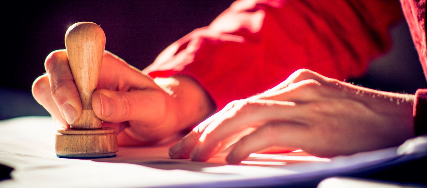 Der Übersetzer setzt einen runden Stempel auf die Übersetzung.